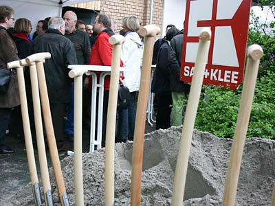 Spaten stecken in einem Sandhügel